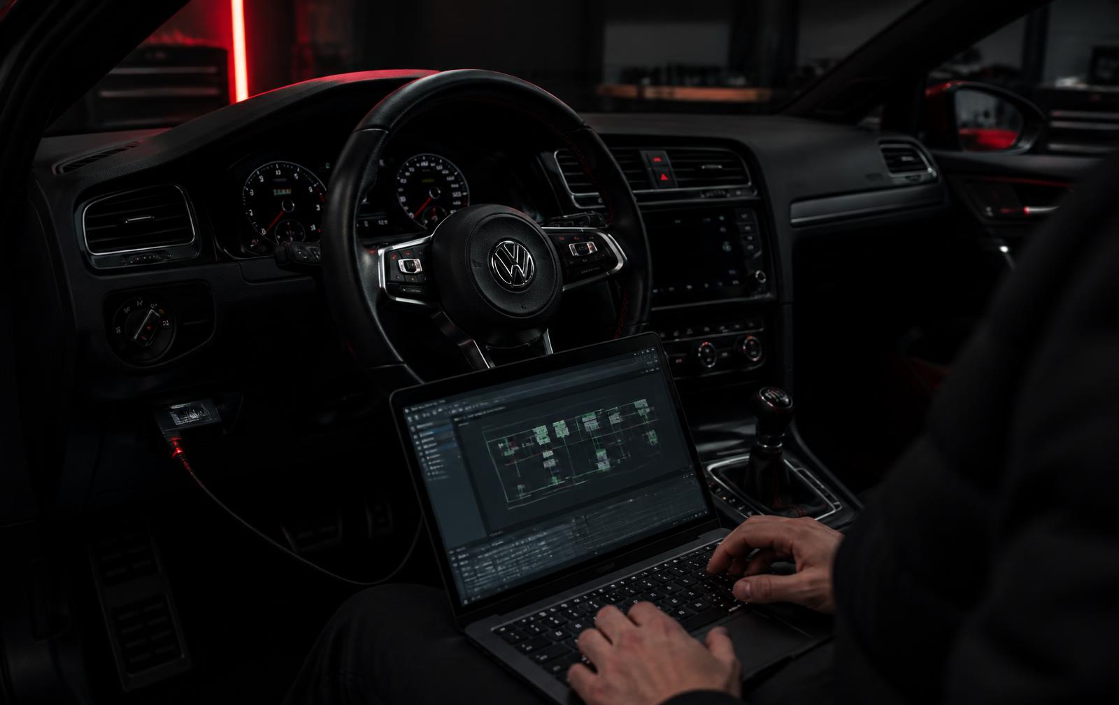 Técnico trabajando con un portátil conectado a la centralita de un Golf GTI